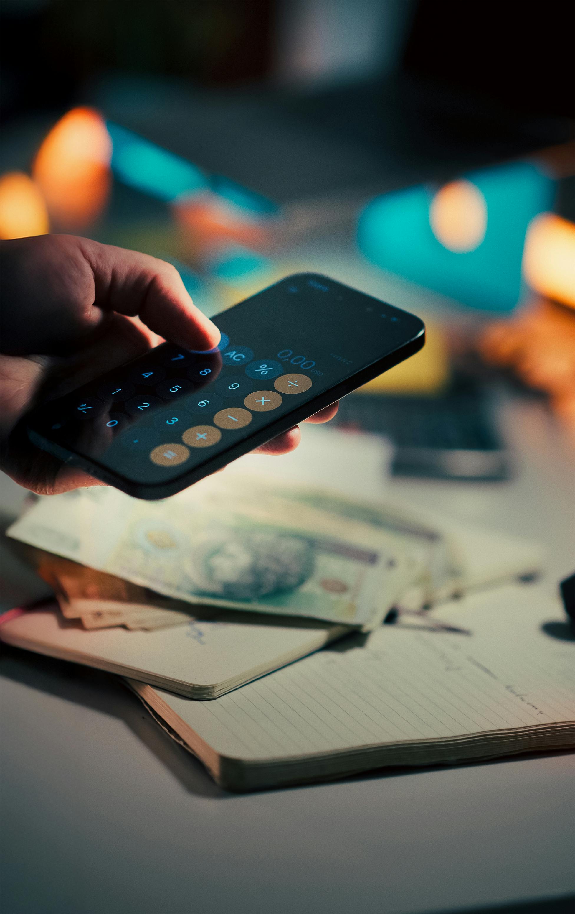 Калькулятор на телефоне и деньги для расчета кредитной нагрузки